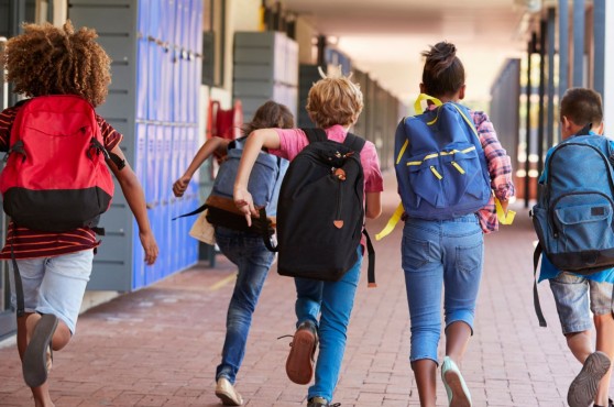 Un grup d'infants corrents cap al pati de l'escola.