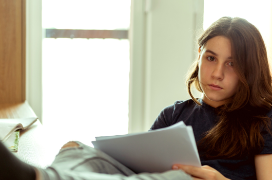 Adolescent estudiant a la seva habitació
