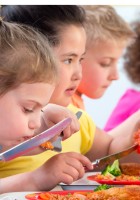 Niños y niñas comiendo.