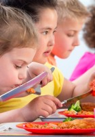 Niños y niñas comiendo.